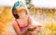 A young child with goggles on playing with water outside