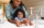 A mom and child washing their hands together under the sink